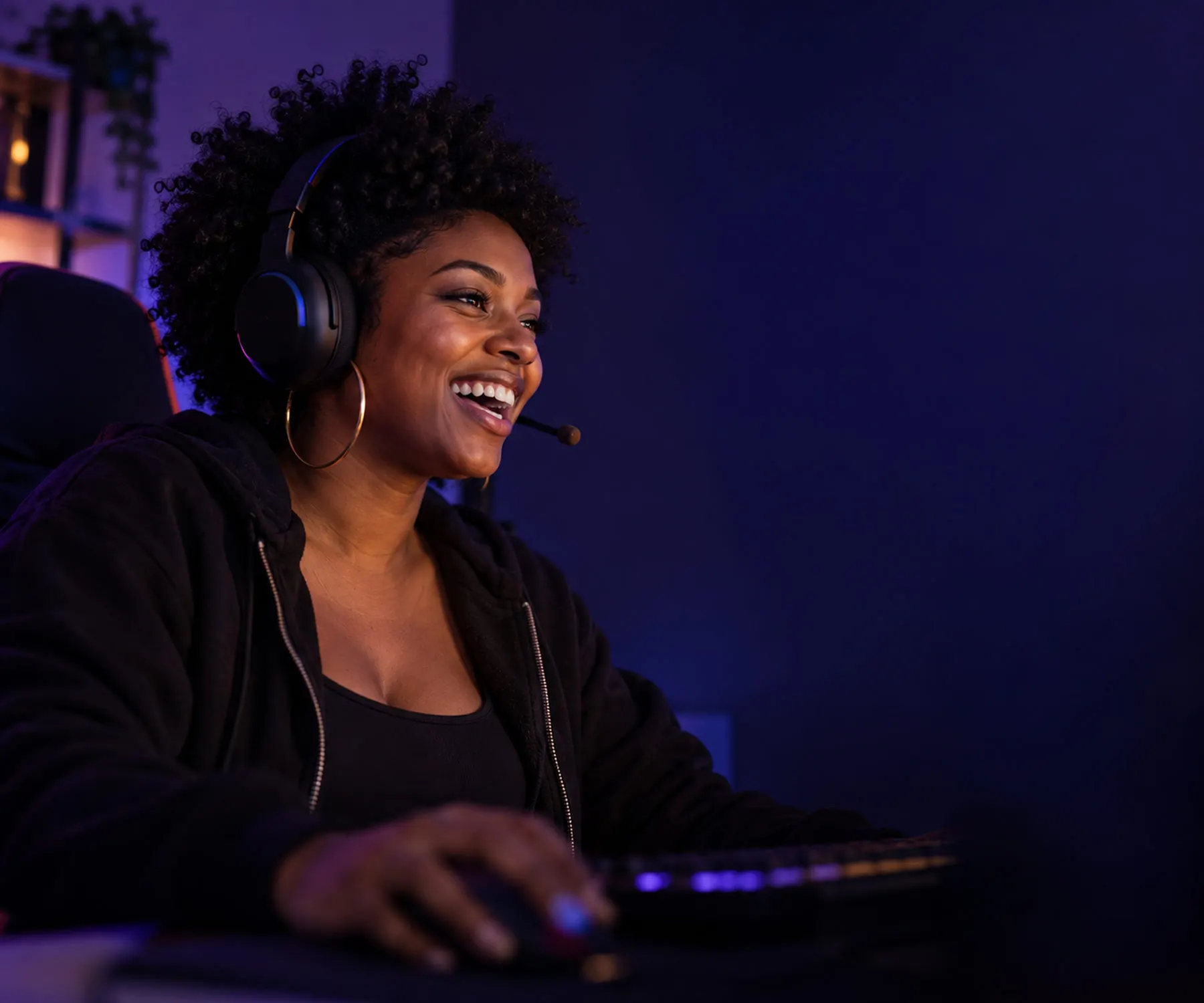 Laughing woman with a gaming headset talking to her team during a game